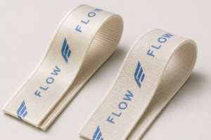 Nylon and polyester sports bra straps with the same blue woven logo showing different surface textures