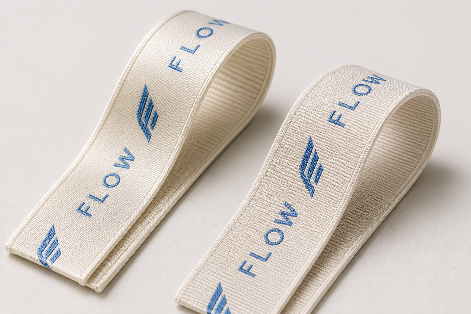 Nylon and polyester sports bra straps with the same blue woven logo showing different surface textures
