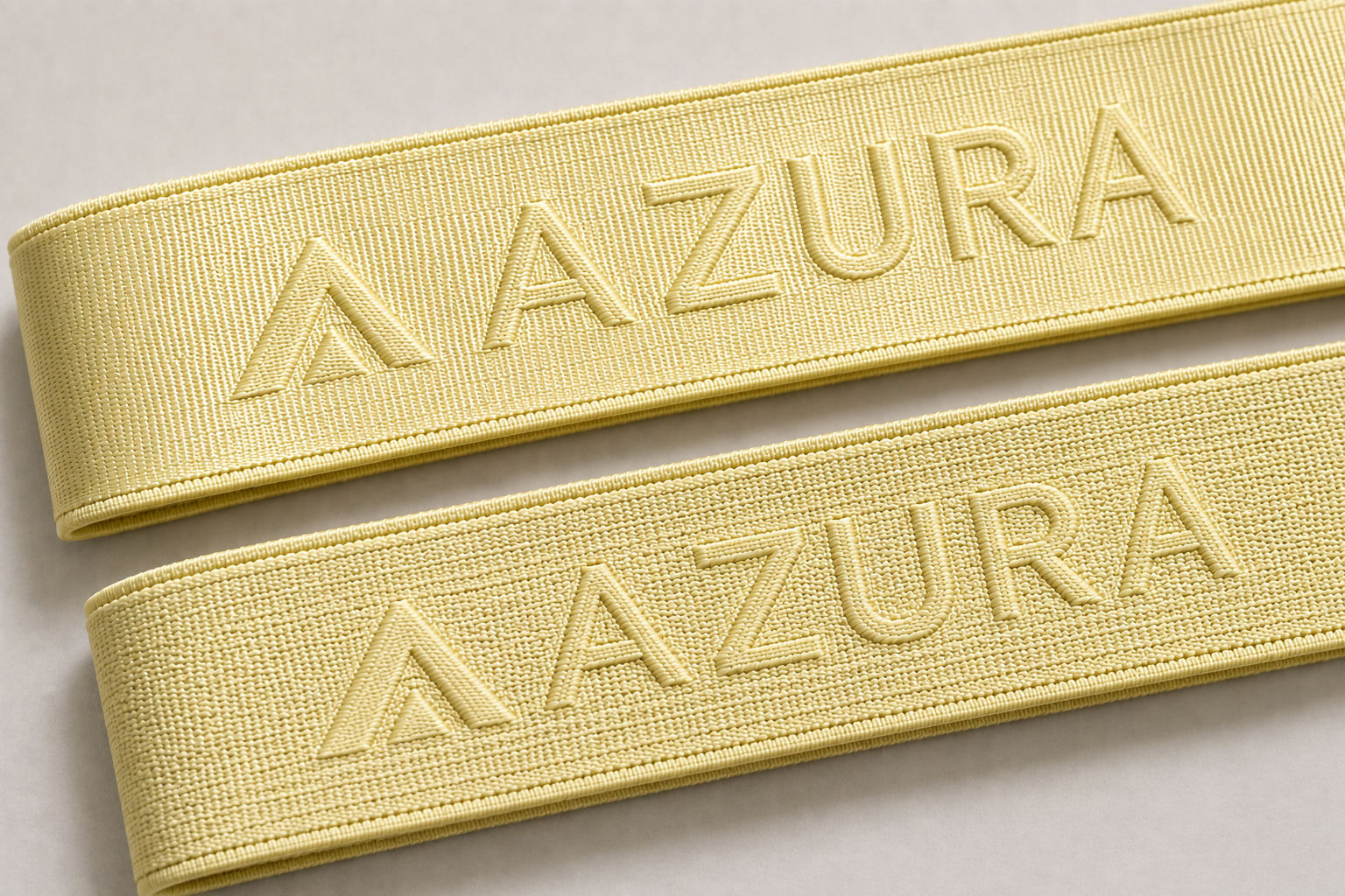 Light yellow sports bra straps comparing smooth and textured woven logo finishes