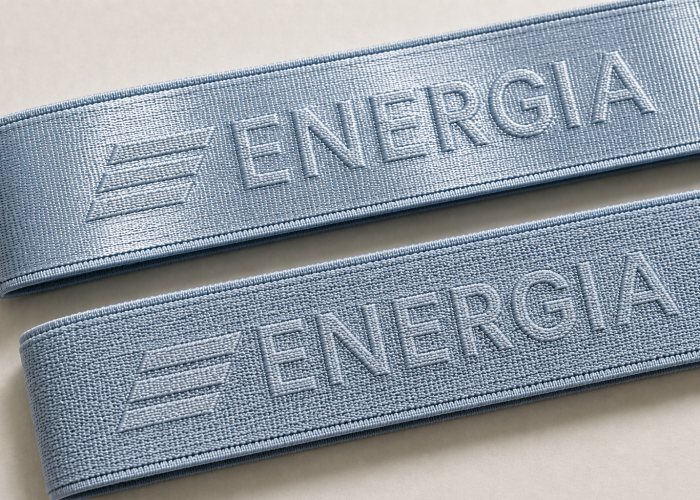 Light blue nylon and polyester sports bra straps with the same woven logo showing different surface appearance