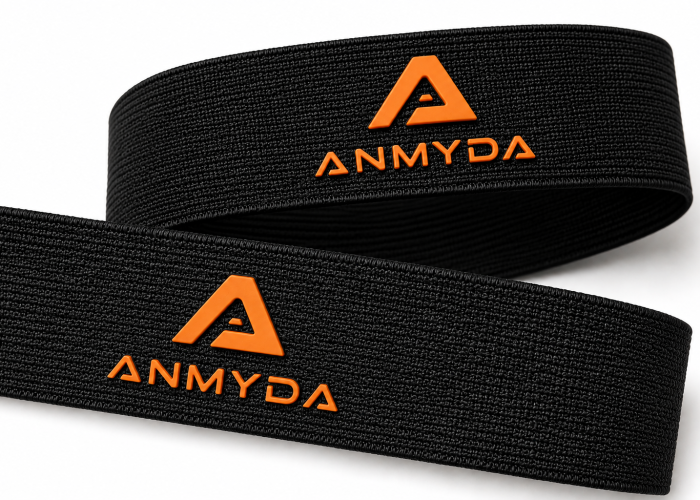 Black polyester webbing with raised orange silicone logos on the surface