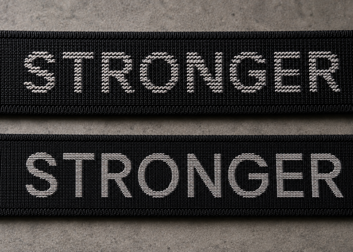 Two black jacquard sports bra straps with the same woven logo but different logo clarity