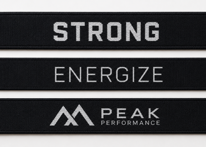 Small woven logos with different detail complexity on black sports bra straps