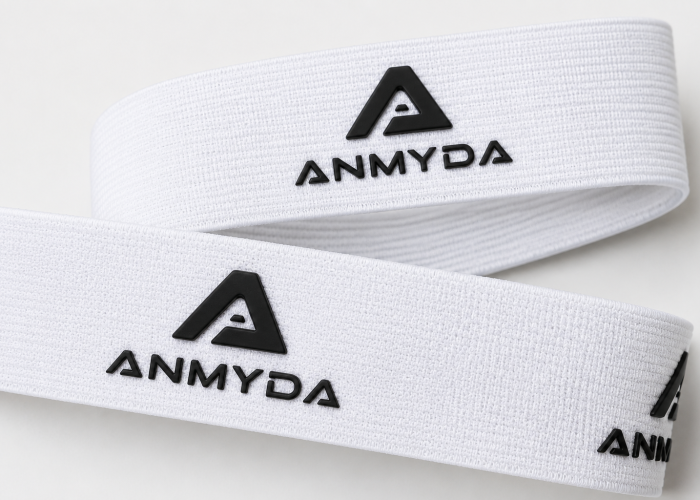 White elastic webbing with raised black silicone logos printed on the surface