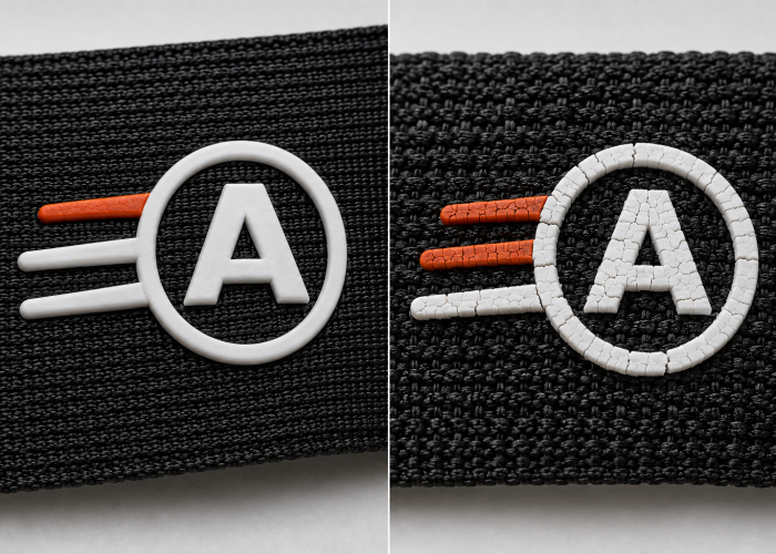 Silicone logo intact on smooth webbing and cracked on rough textured webbing.